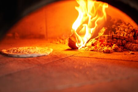 Baked tasty margherita pizza in Traditional wood oven in Naples restaurant, Italy. Original...