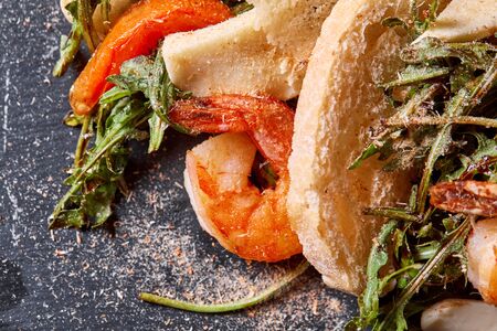 Delicious dish with grilled shrimps, squid, croutons and arugula salad and spicy fried prawns. Restaurant menu, natural and organic food concept.の写真素材