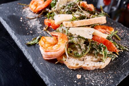 Delicious dish with grilled shrimps, squid, croutons and arugula salad and spicy fried prawns. Restaurant menu, natural and organic food concept.の写真素材