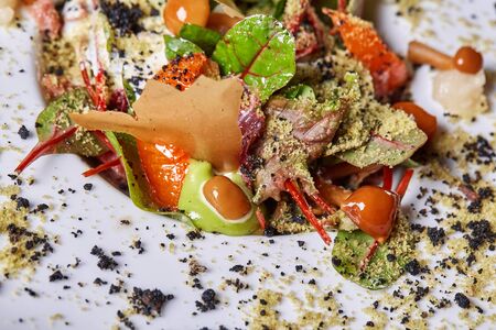 Salad with honey agaric mushroom and potato. A hearty nice salad for the festive table. Lettuce leaves, greenery, arugula, mushrooms chanterelles and dried tomatoes.の写真素材