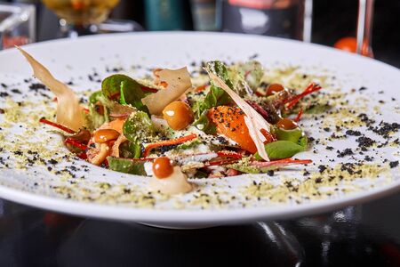 Salad with honey agaric mushroom and potato. A hearty nice salad for the festive table. Lettuce leaves, greenery, arugula, mushrooms chanterelles and dried tomatoes.の写真素材