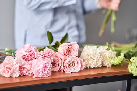 European floral shop. Beautiful bouquet of mixed flowers in womans hands. the work of the florist at...