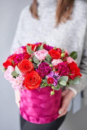 Red and violet floral bunch in Velour round box. European floral shop. Bouquet of beautiful Mixed...