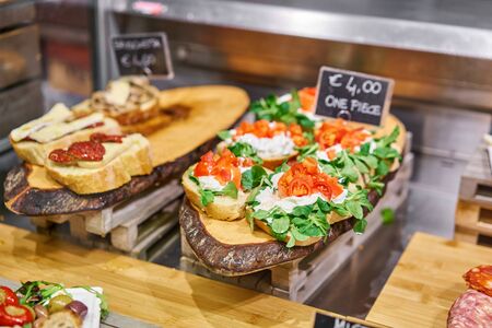 Bruschetta with prosciutto, Basil, Parmesan and sun-dried tomatoes. Street food market in Florence,...