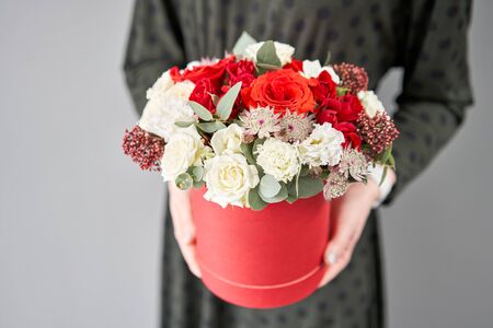 Red and white floral bunch in round box. European floral shop. Bouquet of beautiful Mixed flowers in...