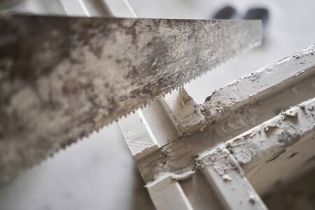 Saw in hand saws Gypsum plate. Construction of internal walls in the apartment using a plaster concrete plate with groove ridge. New building without finishing. tongue-and-groove gypsum blocksの写真素材