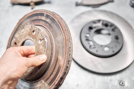 Old used and new to change for safety car brake disc and pad on metal table of an auto mechanic. Auto repair concept.の写真素材