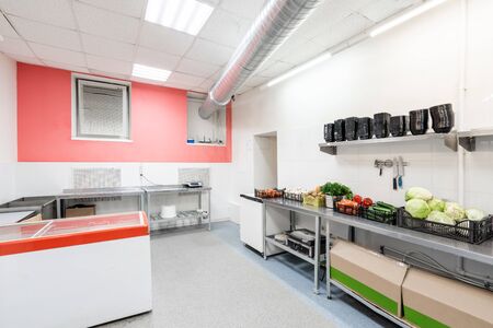 Modern restaurant kitchen with stainless steel kitchenware and equipment. Cooking with preparation tables, pans, pots, stovesの写真素材