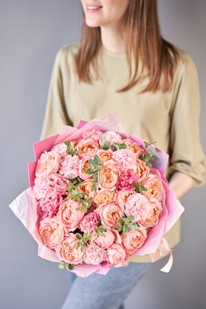Beautiful bouquet of mixed flowers in womans hands. the work of the florist at a flower shop. Delivery fresh cut flower. European floral shopの写真素材