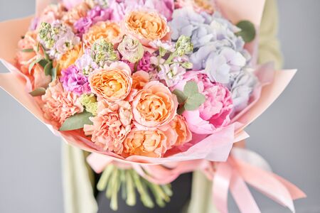 Pink peonies and hydrangea. Beautiful bouquet of mixed flowers in woman hand. Floral shop concept . Handsome fresh bouquet. Flowers delivery.の写真素材