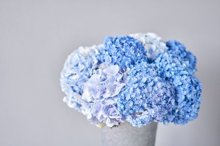 Beautiful blue hydrangea flowers in a vase on a table . Bouquet of light pink flower. Decoration of home. Wallpaper and background.の写真素材
