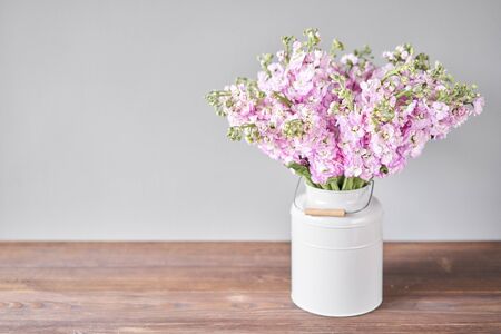 Bouquet of Beautiful lilac mattiola. Spring flowers in vase on wooden table. Flowers delivery.の写真素材