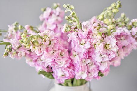 Bouquet of Beautiful lilac mattiola. Spring flowers in vase on wooden table. Flowers delivery.の写真素材