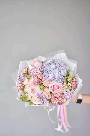 Beautiful bouquet of mixed flowers in woman hand. Floral shop concept . Handsome fresh bouquet. Flowers delivery.の写真素材