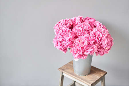 Beautiful pink hydrangea flowers in a vase on a table . Bouquet of light pink flower. Decoration of home. Wallpaper and background. fuchsia colorの写真素材