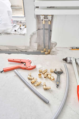Tools for Work As A Plumber. Connection heating pipes to white Radiator in a new apartment under construction. water heating radiator on the white wall indoorsの写真素材