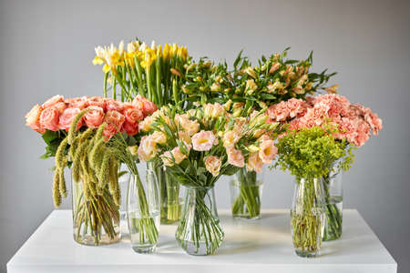 Many different colors on the stand or wooden table in the flower shop. Showcase. Background of mix of flowers. Beautiful flowers for catalog or online store.の写真素材