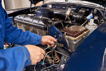 Retro car, Amateur collector repairs his car. Mechanic hands checking up of serviceability of the...