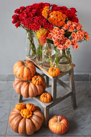 Autumn mood. Set of pumpkins and orange and red flowers for Interior decorations. The work of the florist at a flower shop. Fresh cut flower.の写真素材