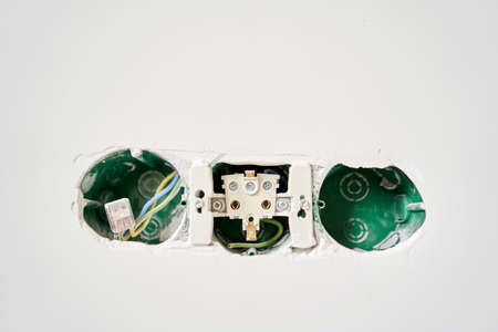 Three sockets. Installation high voltage. Electrical wires sticking out of an electrical outlet on a...