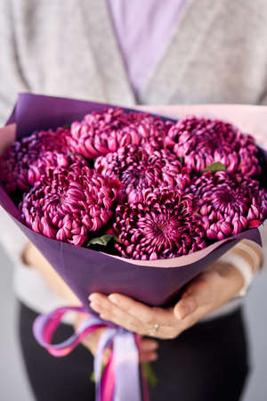 Mono bouquet of chrysanthemum in womans hands. European floral shop. the work of the florist at a flower shop. Delivery fresh cut flower.の写真素材