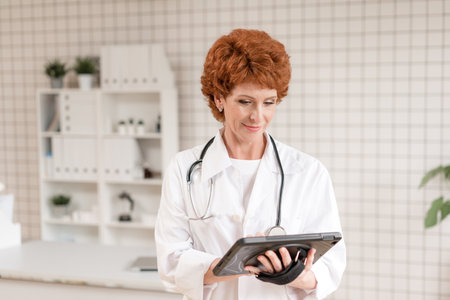 Pediatrician listening to breathing in the lungs and heartbeat with stethoscope. Portrait of adorable little boy visiting doctor.の写真素材