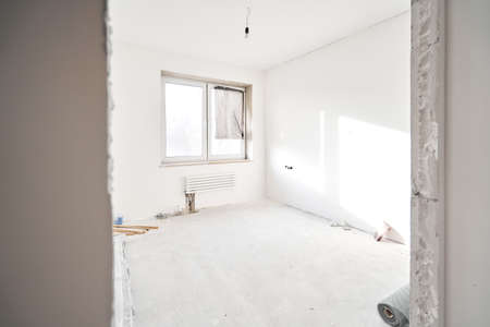 connection heating pipes to white Radiator in a new apartment under construction. Work As A Plumber, mounting water heating radiator on the white wall indoorsの写真素材