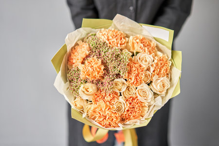 Beautiful bouquet of mixed flowers in woman hand. Floral shop concept . Beautiful fresh cut bouquet. Flowers deliveryの写真素材