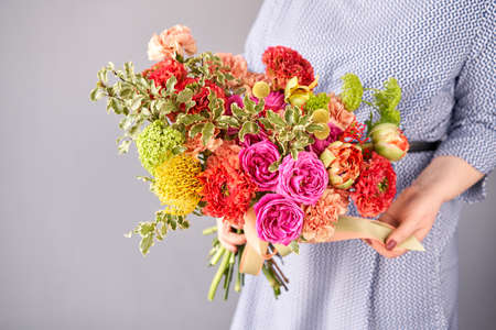 Beautiful bouquet of flowers in woman hand. Floral shop concept . Beautiful fresh cut bouquet. Flowers deliveryの写真素材
