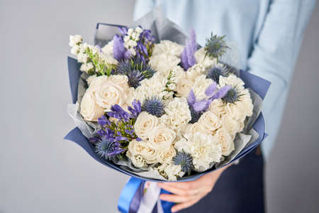Beautiful bouquet of flowers in woman hand. Floral shop concept . Beautiful fresh cut bouquet. Flowers deliveryの写真素材