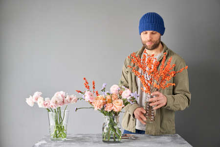 Portrait of a Male florist. Flowers bunch, set for home. Fresh cut flowers for decoration home. European floral shop. Delivery fresh cut flower.の写真素材