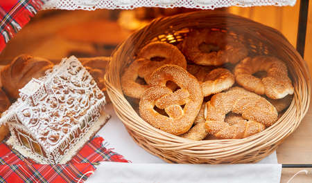 A bakery showcase in a European city for Christmas. Gingerbread house, pretzel, apple crumble, buns. Bread on Christmas and New yearの写真素材