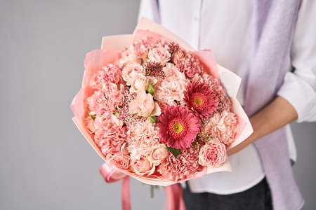 Beautiful large bouquet of mixed flowers without packaging. Handsome fresh bouquet in woman hand. Small flower shop and Flowers delivery.の写真素材