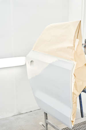 Painting the rear door of the car in special painting chamber. Car service station. Restoring a car after an accidentの写真素材