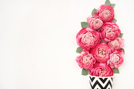 The concept of a flower shop and coffee shop. A coffee cup and flowers. Coffee to go. Petals of...