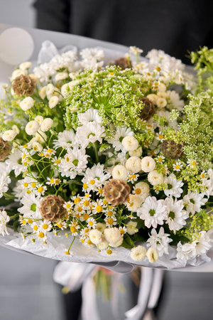 Beautiful bouquet of mixed flowers in woman hand. Floral shop concept . Beautiful fresh cut bouquet. Flowers deliveryの写真素材