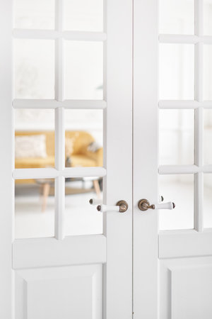 Old-style door, white - handle close up. The interior of a bright living room in a modern apartment.の写真素材