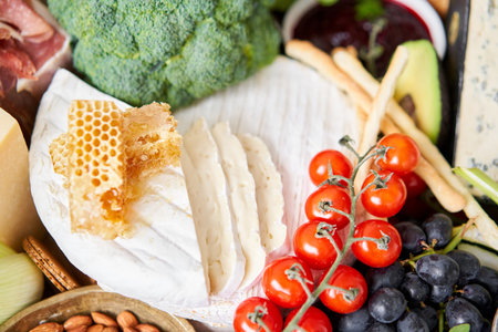 Brie cheese with honey close-up. Table full of mediterranean appetizers, tapas or antipasto. Assorted Italian food set. Delicious snack on party or picnic time. Italian style banquet.の写真素材