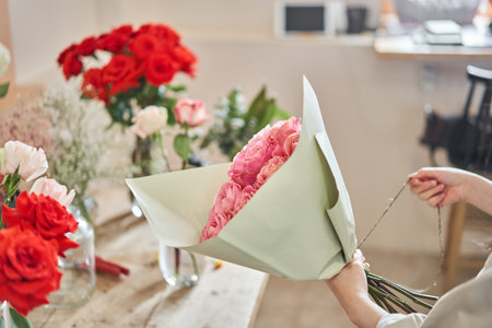 Florist at work. Summer bouquet of roses. Learning flower arranging, making beautiful bouquets with your own hands. Flowers deliveryの写真素材