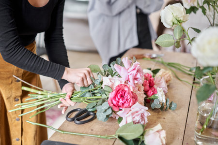 Florist at work. Young woman making fashion modern bouquet in korean style of different flowers. Summer bouquet. Learning flower arranging, making beautiful bouquets with your own hands. Flowers deliveryの写真素材
