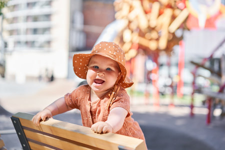 Portraits of a cute 10 months old baby girl. Walking on the playground, on a sunny summer day.の写真素材