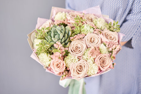 Beautiful bouquet of mixed flowers in woman hand. Floral shop concept . Beautiful fresh cut bouquet. Flowers deliveryの写真素材