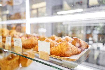 Lot of croissant is fresh and hot in a cafe next to other types of pastries. A variety of fresh pastries in the bakery window. The interior of an Italian restaurant.の写真素材
