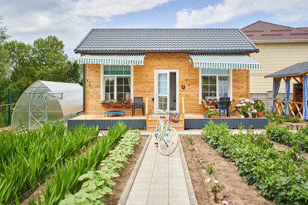 Retro bicycle with basket flowers. Flower field on the sunny morning. Beautiful flower seedlings growing in the soil at the garden. Gardening hobby concept.の写真素材