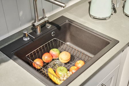 Stylish metallic crane at the kitchen. Sink faucet at the kitchen. Metal crane in close-up photo. Details of the interior of the kitchen in the house.の写真素材