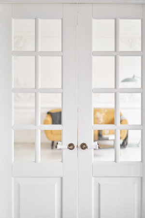 Old-style door, white - handle. The interior of a bright living room in a modern apartment.の写真素材