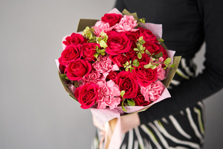 Beautiful bouquet of flowers in woman hand. Floral shop concept . Beautiful fresh cut bouquet. Flowers deliveryの写真素材