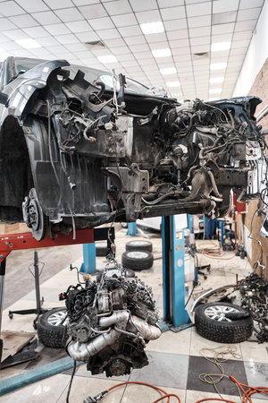 A car mechanic inspects the engine with a flashlight. Engine Block on a repair stand with Special...