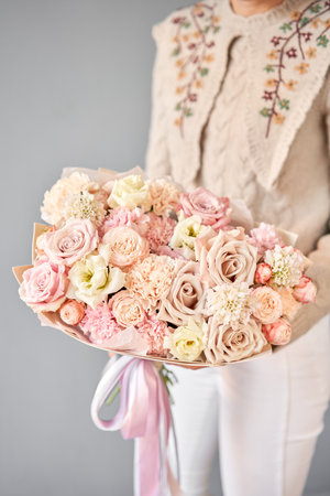 Beautiful bouquet of mixed flowers in woman hand. Floral shop concept . Beautiful fresh cut bouquet. Flowers deliveryの写真素材