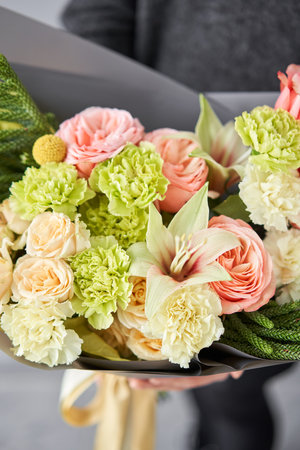 Beautiful bouquet of flowers in woman hand. Floral shop concept . Beautiful fresh cut bouquet. Flowers deliveryの写真素材